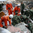 武警官兵在四川汶川县映秀镇的房屋废墟中搜救幸存者