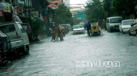 6月22日，受台风“风神”的影响，菲律宾首都马尼拉贫民区的一条道路严重积水。新华社记者许林贵摄